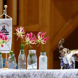 Gloriosen (Nationalblume Simbabwes) schmücken den Altar beim WGT Graz-Nord